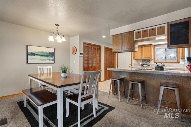 502 Lake Cascade Pkwy Unit 6, Cascade, ID 83611 - dining area with light carpet, a chandelier, recessed lighting, a textured ceiling, and baseboards