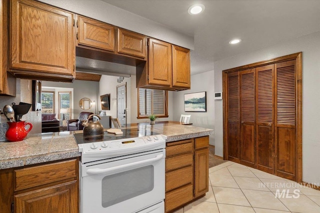 502 Lake Cascade Pkwy Unit 6, Cascade, ID 83611 - kitchen with electric stove, brown cabinetry, light tile patterned floors, recessed lighting, and tile countertops