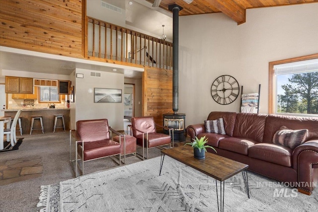 502 Lake Cascade Pkwy Unit 6, Cascade, ID 83611 - living room with a wood stove, carpet flooring, a towering ceiling, and wooden ceiling with exposed beams