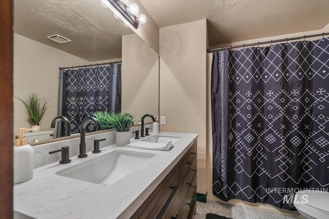 502 Lake Cascade Pkwy Unit 6, Cascade, ID 83611 - full bathroom featuring a textured ceiling, double vanity, toilet, a textured wall, and a shower with curtain