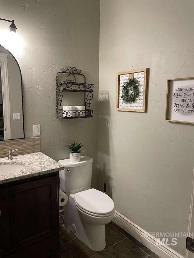 bathroom featuring tile patterned floors, toilet, vanity, and baseboards