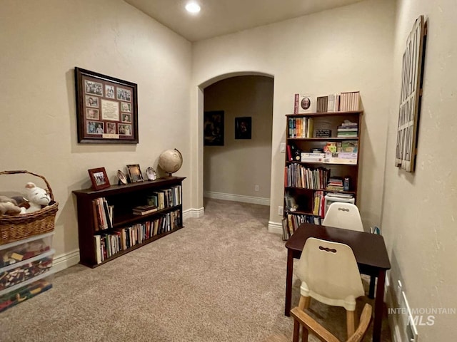 carpeted office featuring arched walkways and baseboards