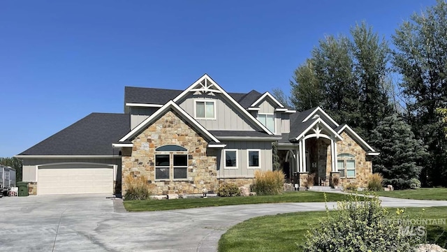 craftsman-style home with an attached garage, driveway, a front yard, and board and batten siding