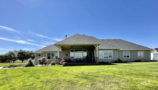 rear view of property with a patio, a ceiling fan, a yard, and a shingled roof