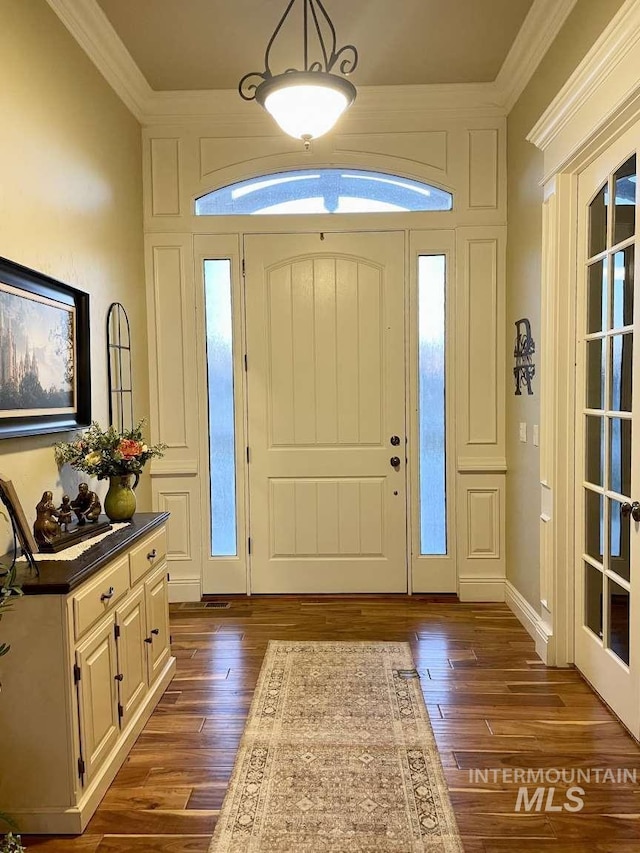 entrance foyer featuring dark wood finished floors and crown molding