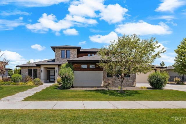 prairie-style home with driveway, stone siding, and a front lawn