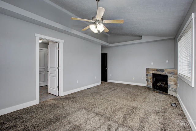 unfurnished living room with baseboards, visible vents, a fireplace, vaulted ceiling, and carpet flooring