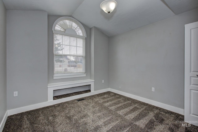 empty room featuring vaulted ceiling, baseboards, visible vents, and carpet floors