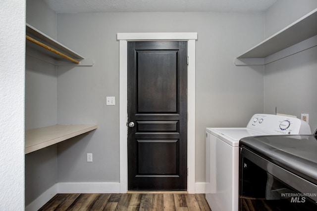 laundry room featuring dark wood finished floors, baseboards, washing machine and dryer, and laundry area