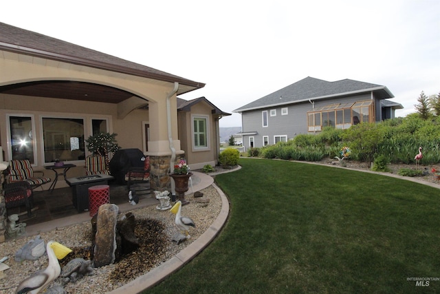 back of property featuring a lawn, central AC, and stucco siding