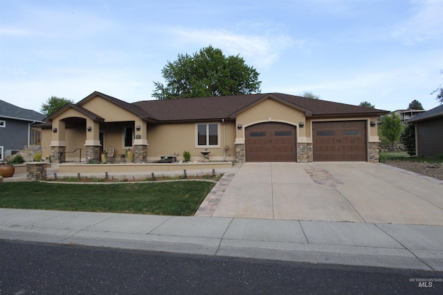 single story home featuring a garage, a front lawn, concrete driveway, stone siding, and stucco siding