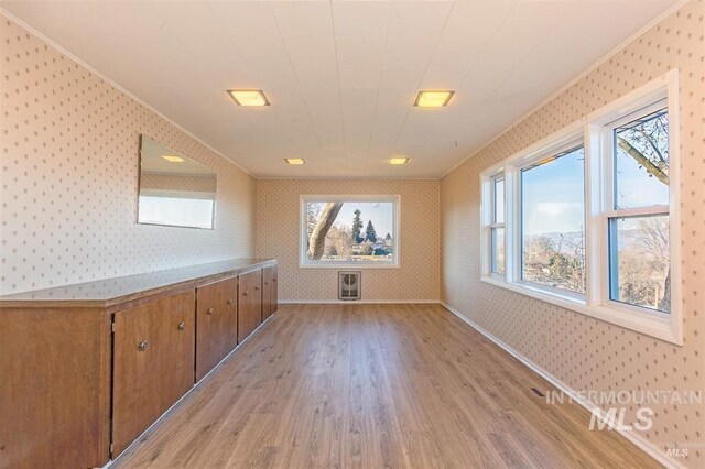 1605 Vineyard Dr, Lewiston, ID 83501 - unfurnished room featuring wallpapered walls, crown molding, light wood-style flooring, plenty of natural light, and heating unit