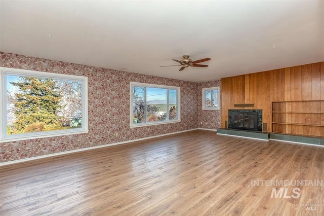 1605 Vineyard Dr, Lewiston, ID 83501 - unfurnished living room with ceiling fan, wood finished floors, a glass covered fireplace, and wallpapered walls
