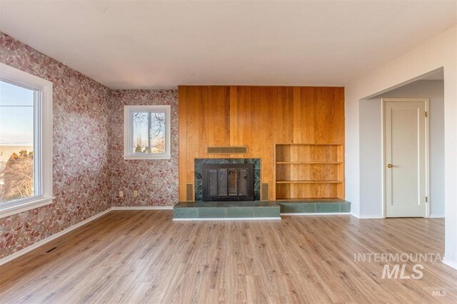 1605 Vineyard Dr, Lewiston, ID 83501 - unfurnished living room featuring a glass covered fireplace, wood finished floors, and wallpapered walls