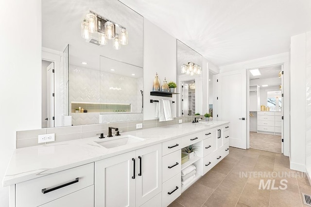 full bath featuring tile patterned floors, a sink, backsplash, and double vanity