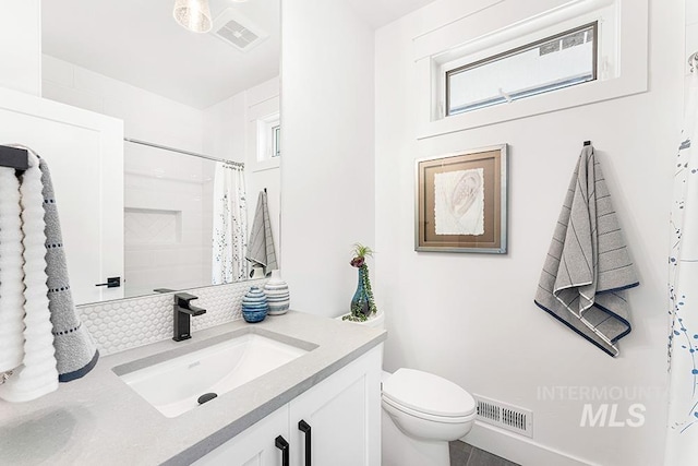 bathroom with toilet, visible vents, a shower with shower curtain, and vanity