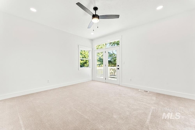 spare room with recessed lighting, light colored carpet, ceiling fan, and baseboards