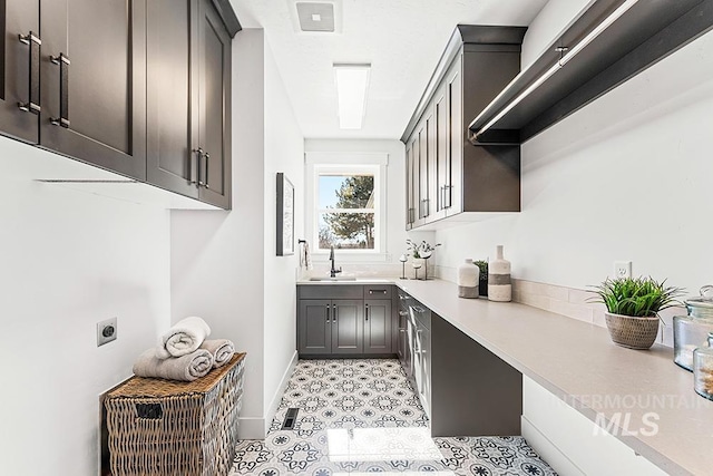 interior space with a sink, visible vents, and baseboards