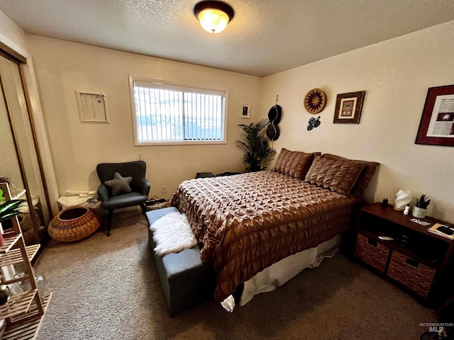 bedroom featuring dark carpet and a textured ceiling