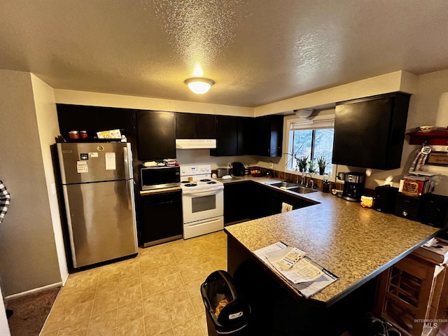 kitchen featuring sink, a textured ceiling, appliances with stainless steel finishes, a kitchen breakfast bar, and kitchen peninsula