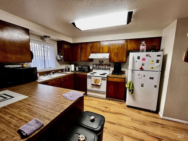 kitchen featuring sink, light hardwood / wood-style flooring, a textured ceiling, kitchen peninsula, and white appliances