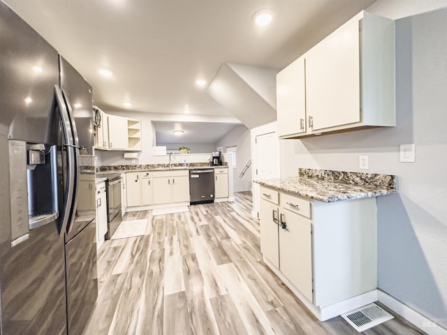 kitchen featuring visible vents, appliances with stainless steel finishes, white cabinetry, a sink, and light wood-style floors