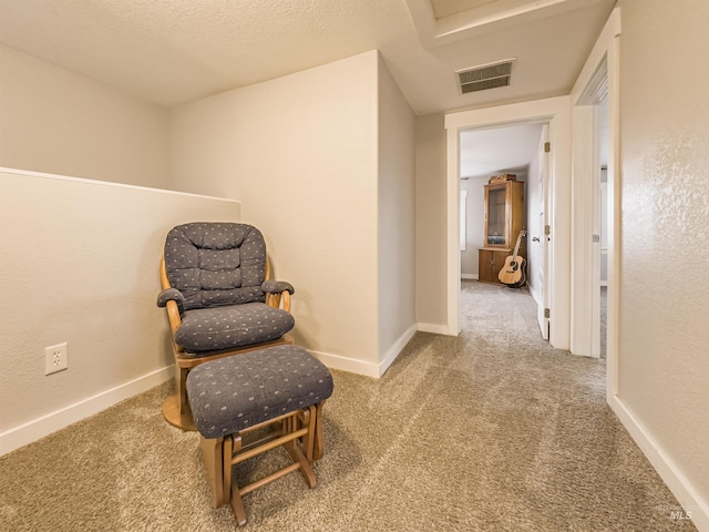 living area with baseboards, visible vents, and carpet flooring