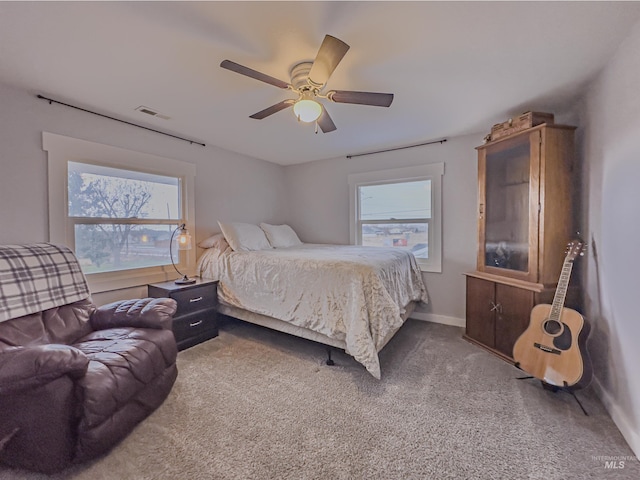 bedroom with multiple windows, visible vents, carpet floors, and baseboards