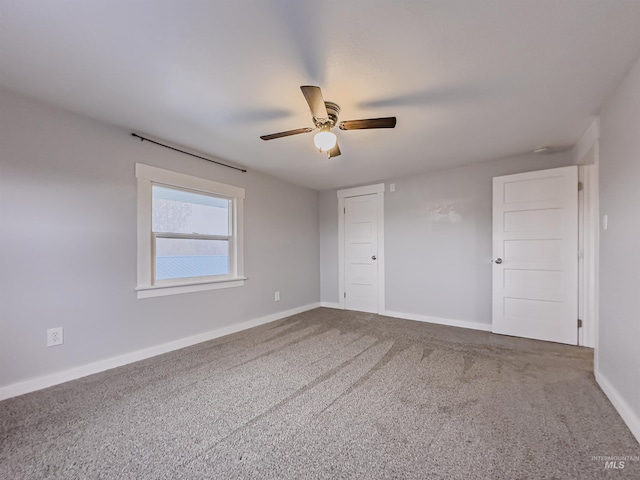 spare room with a ceiling fan, carpet, and baseboards