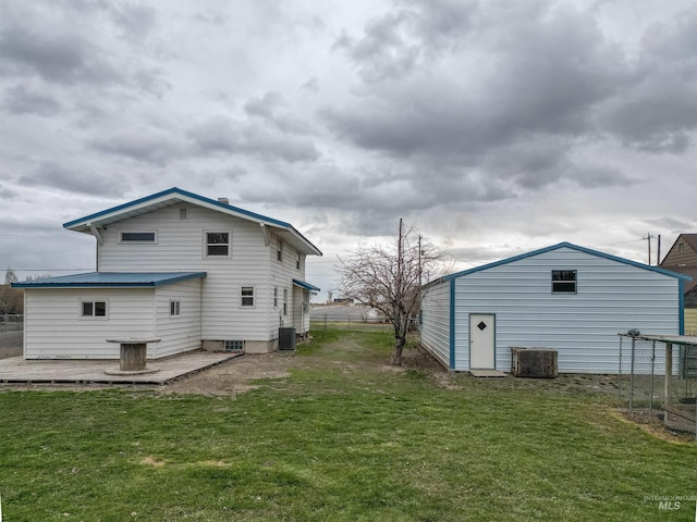 rear view of property featuring fence, central AC unit, and a yard