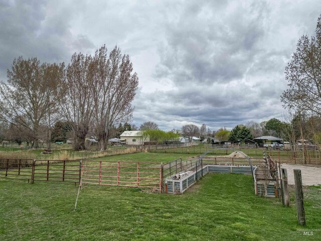 view of yard with fence and a rural view