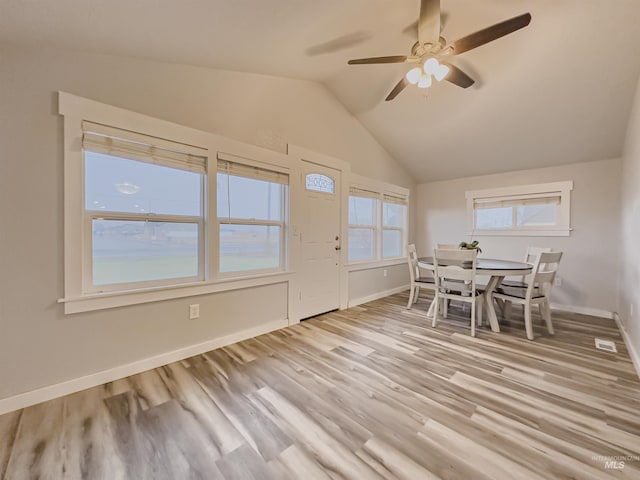 unfurnished dining area with baseboards, lofted ceiling, a ceiling fan, and light wood-type flooring