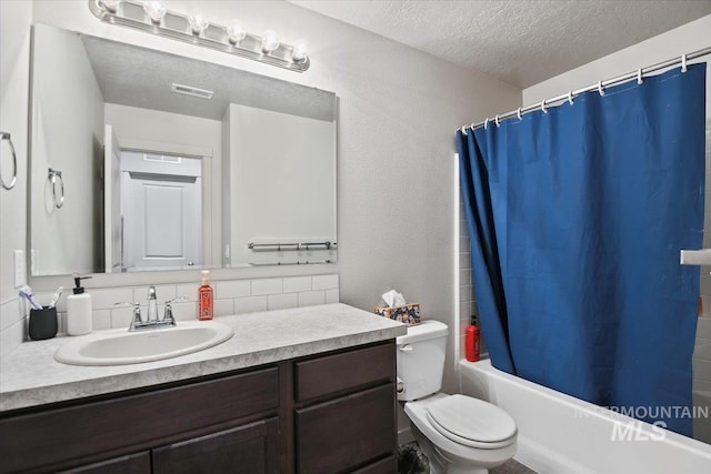 bathroom with a textured ceiling, toilet, vanity, visible vents, and decorative backsplash