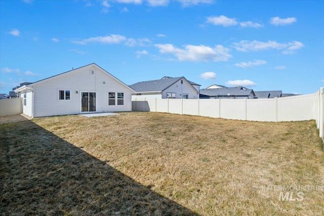 back of house featuring a fenced backyard and a yard