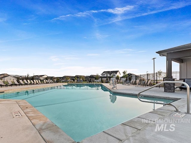 pool featuring a patio area, fence, and a residential view