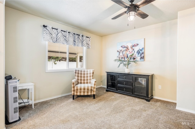 living area featuring carpet floors, a ceiling fan, and baseboards