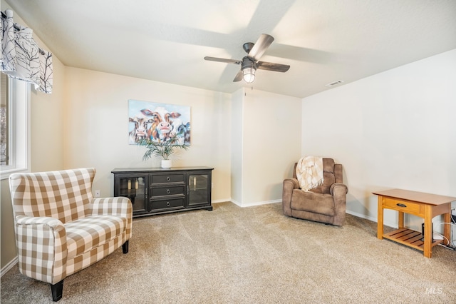 sitting room featuring carpet floors, visible vents, baseboards, and a ceiling fan