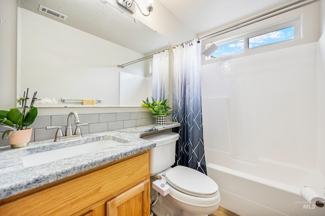 full bathroom featuring toilet, vanity, visible vents, and shower / tub combo with curtain