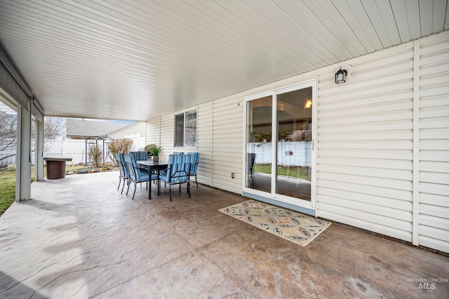 view of patio with outdoor dining area and fence