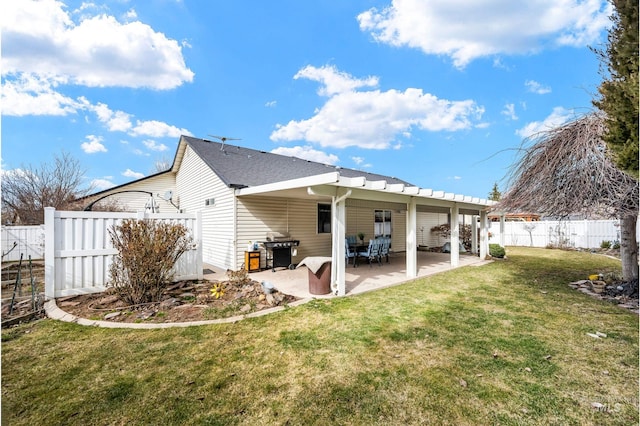 rear view of property featuring a fenced backyard, a yard, and a patio