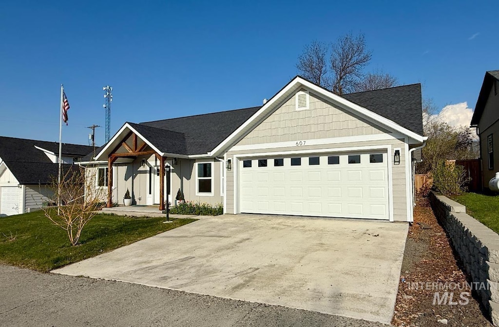 607 C St, Grangeville, ID 83530 - view of front of property featuring a front yard, driveway, an attached garage, and board and batten siding