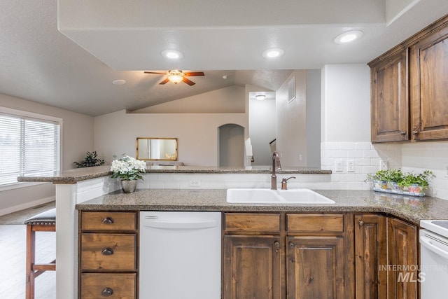 kitchen featuring visible vents, a ceiling fan, a sink, white dishwasher, and lofted ceiling