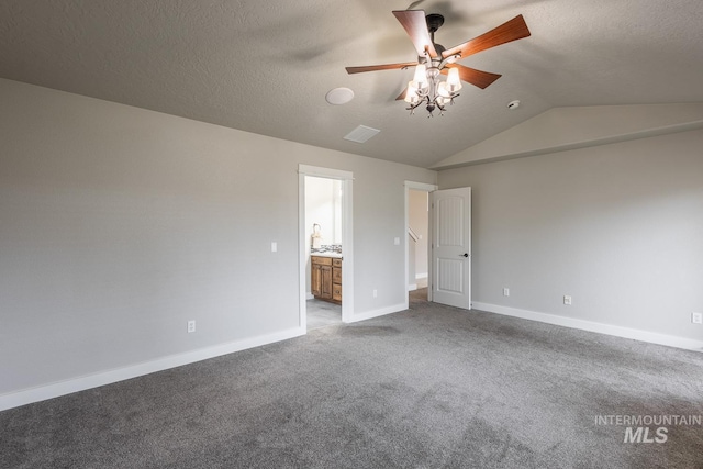 unfurnished bedroom with lofted ceiling, carpet, baseboards, and a textured ceiling