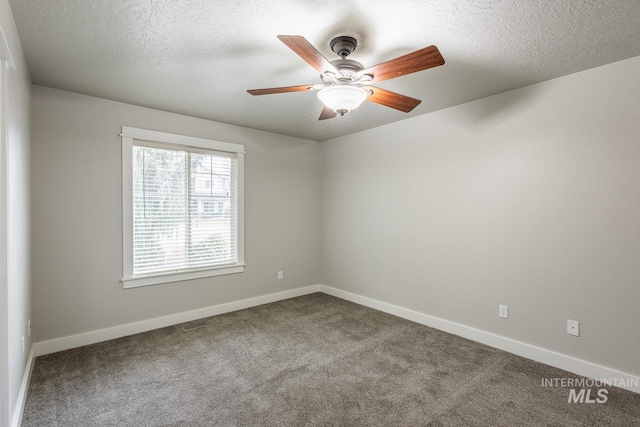 carpeted empty room featuring a textured ceiling, baseboards, and ceiling fan