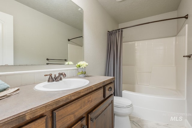 full bath featuring toilet, marble finish floor, a textured ceiling, shower / tub combo, and vanity