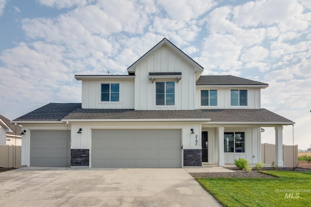 modern inspired farmhouse featuring a front lawn and a garage