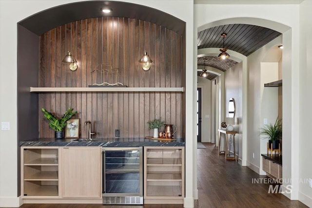 507 Falling Leaf Ln, Twin Falls, ID 83301 - indoor wet bar featuring wine cooler, vaulted ceiling, dark wood-style flooring, and arched walkways
