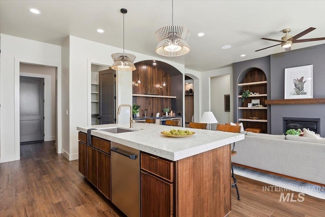 507 Falling Leaf Ln, Twin Falls, ID 83301 - kitchen featuring dishwasher, an island with sink, arched walkways, open floor plan, and dark wood-style floors