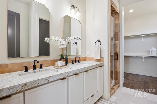507 Falling Leaf Ln, Twin Falls, ID 83301 - full bath featuring double vanity, a shower stall, a walk in closet, wood finished floors, and recessed lighting