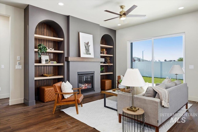 507 Falling Leaf Ln, Twin Falls, ID 83301 - living area with wood finished floors, a glass covered fireplace, a ceiling fan, built in features, and recessed lighting